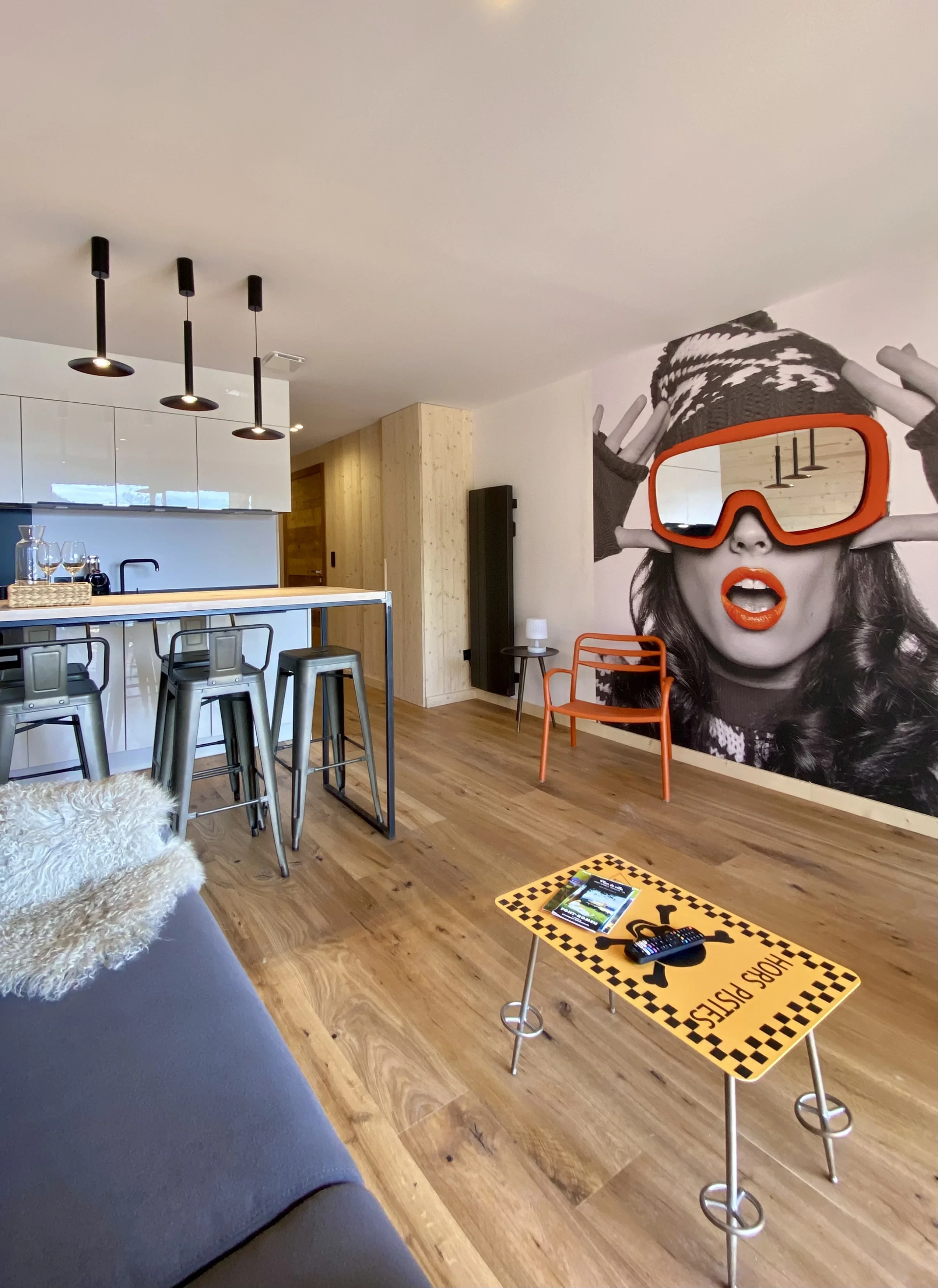 Salon moderne avec fresque murale et cuisine ouverte