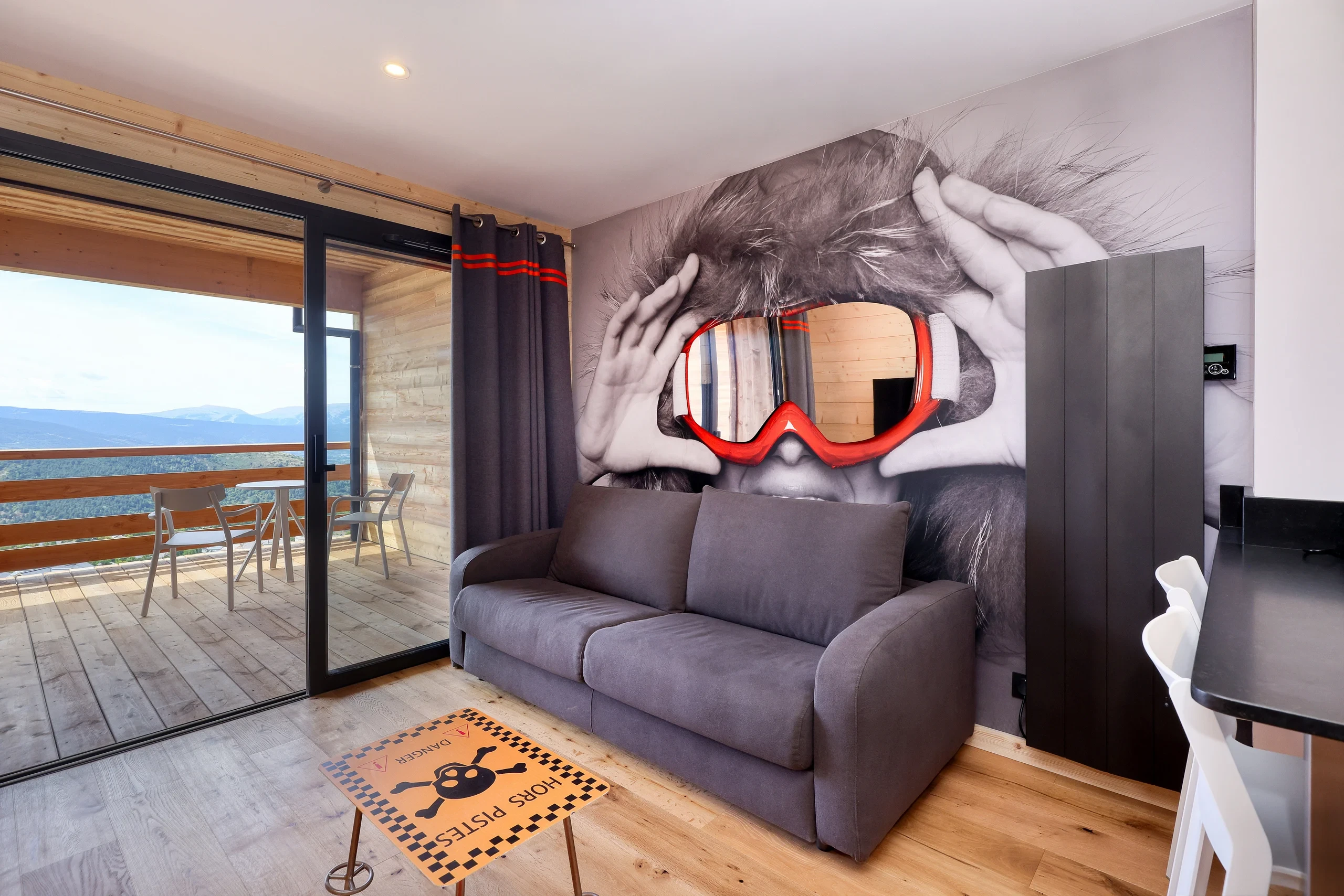 Salon moderne avec fresque et vue montagne