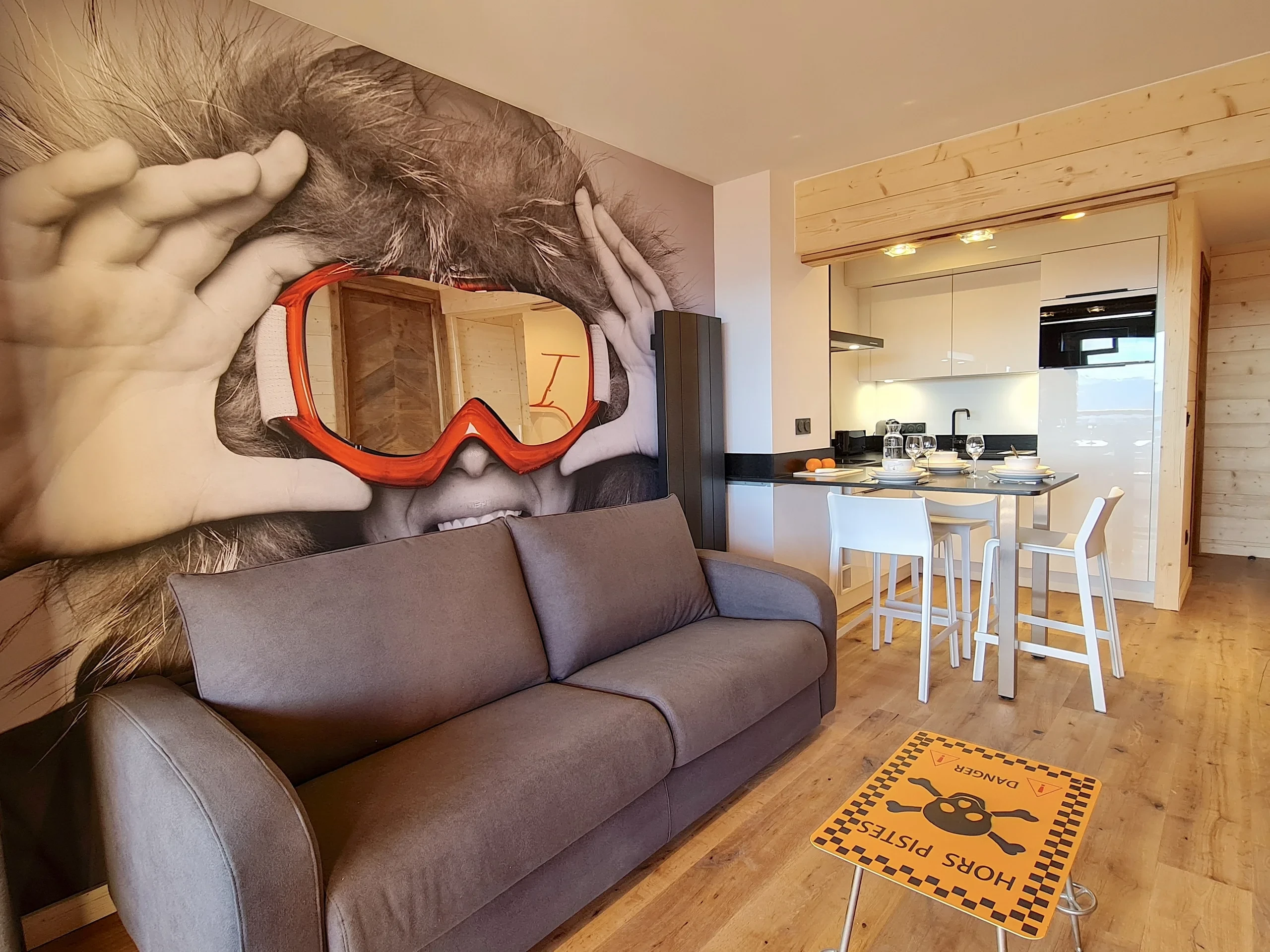 Salon moderne avec fresque murale et cuisine ouverte
