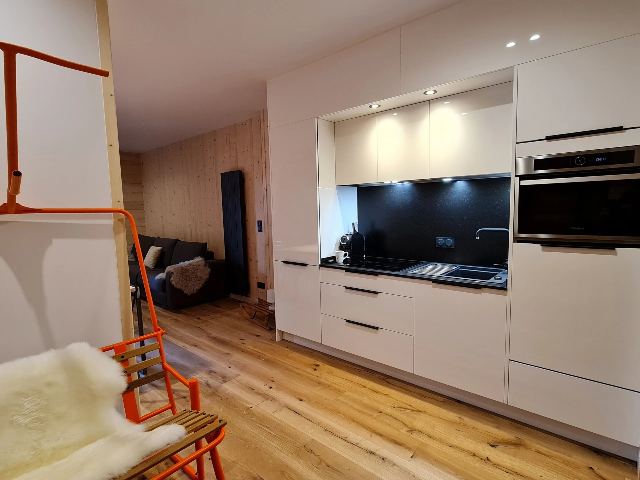 Cuisine moderne blanche avec coin salon en bois