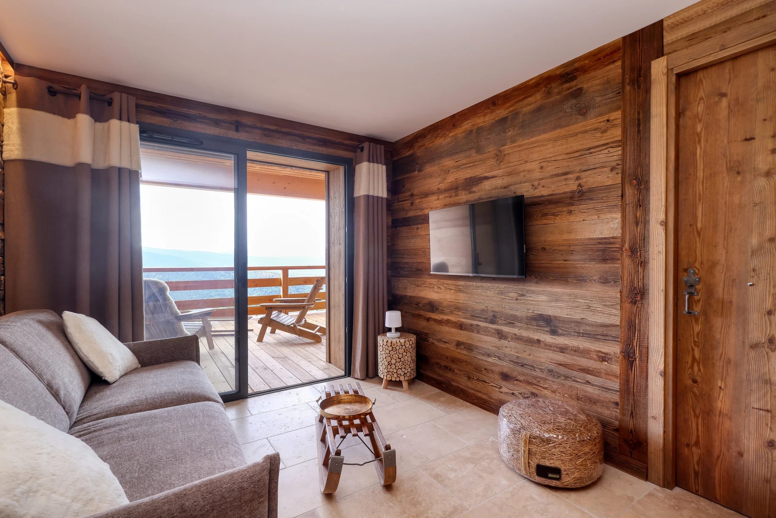 Salon chalet bois avec balcon vue montagnes