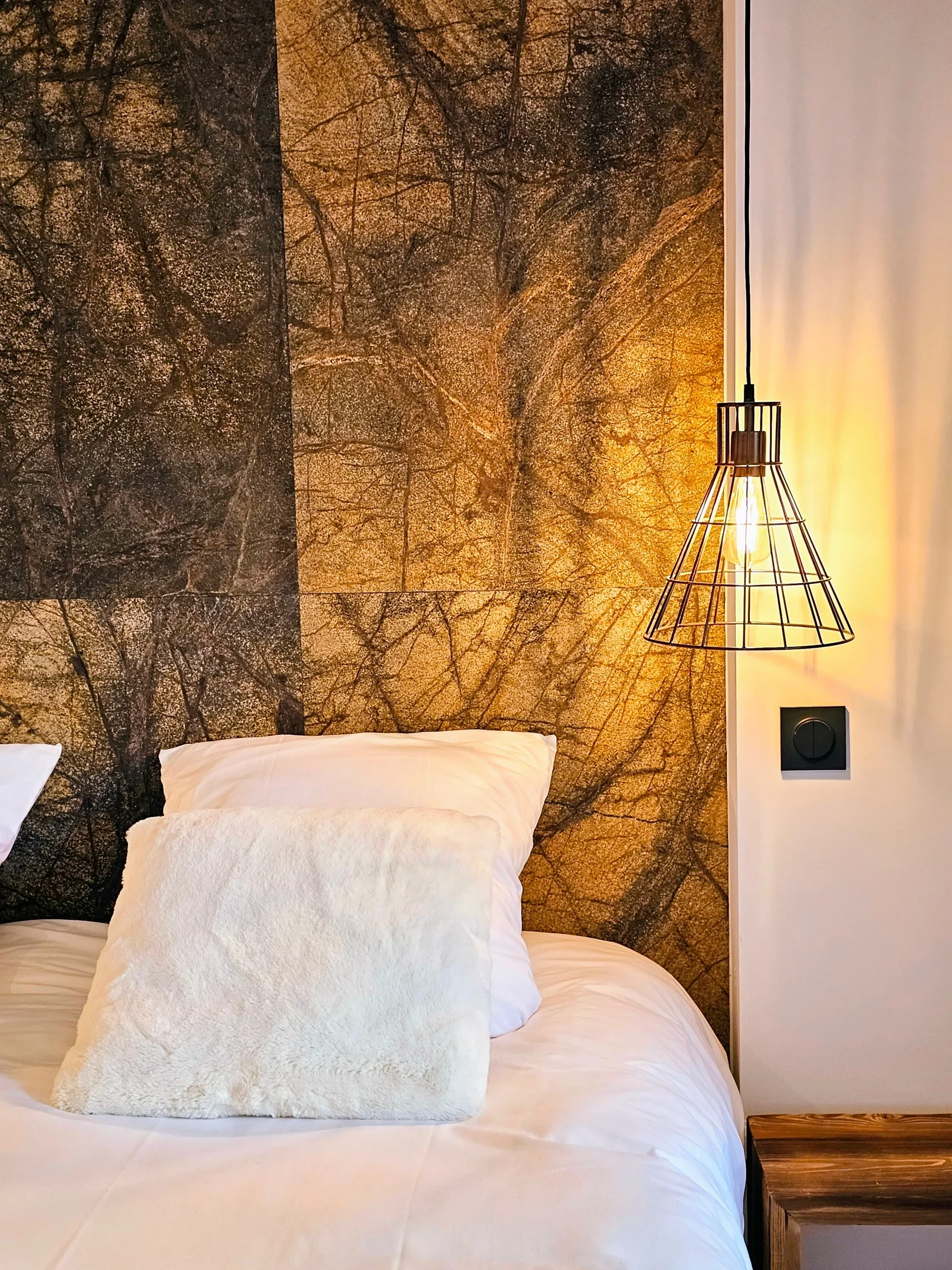 Chambre cosy avec lampe suspendue et mur texturé