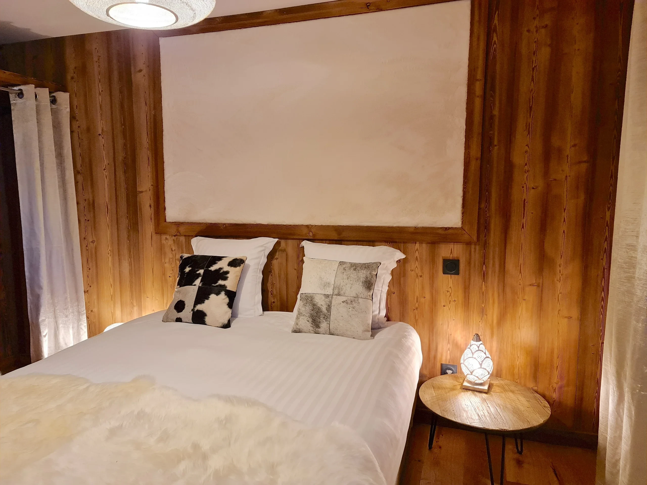 Chambre bois chaleureuse avec lit double et lampe