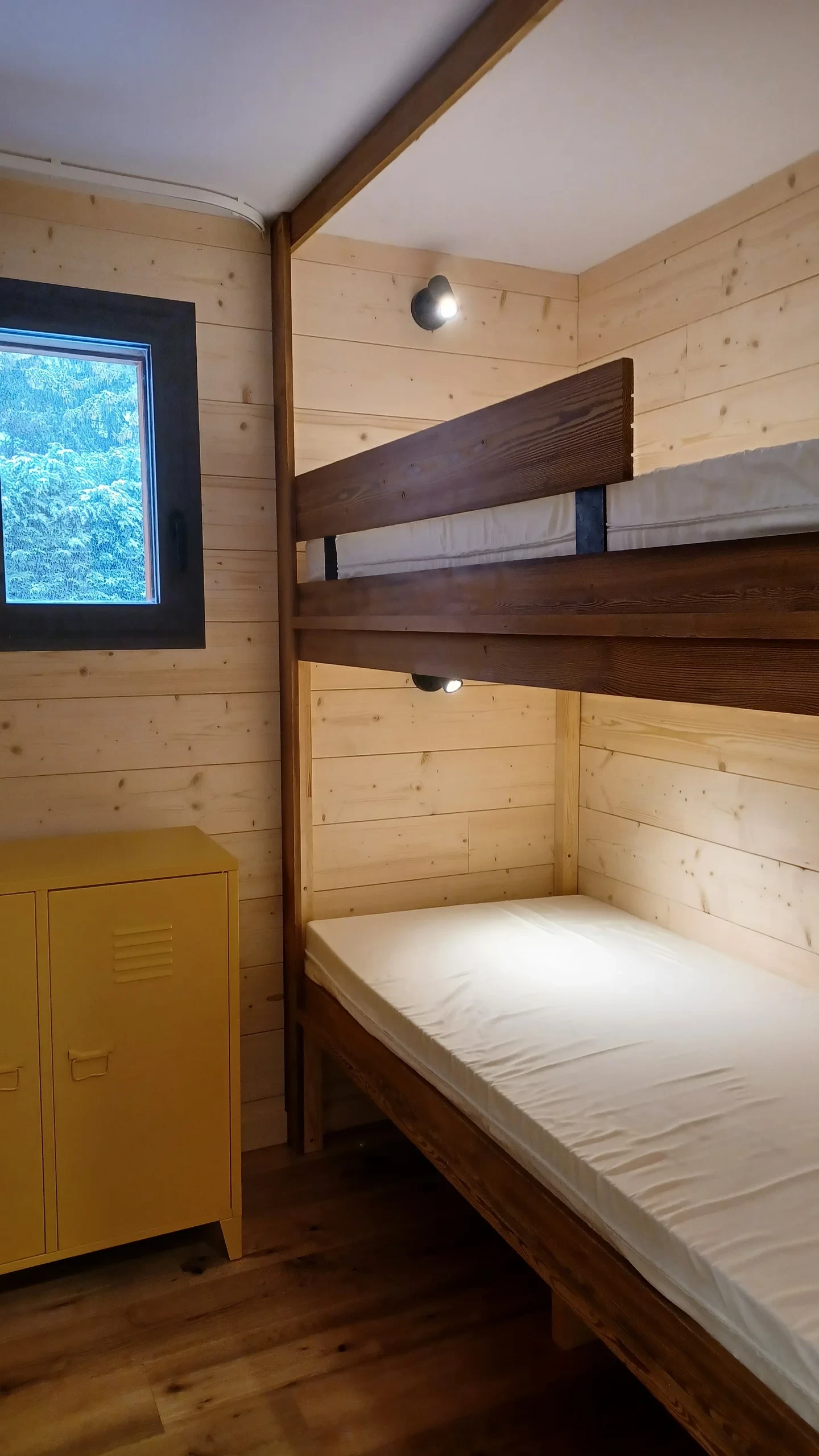 Chambre en bois avec lits superposés rustiques