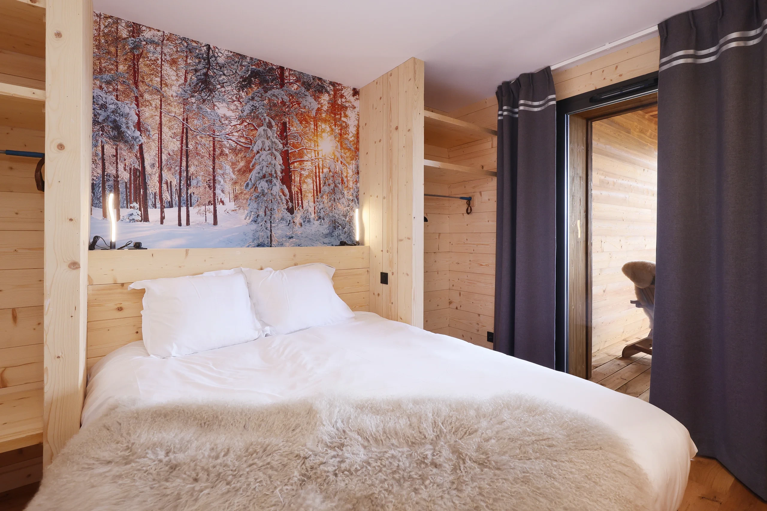 Chambre en bois avec fresque forêt enneigée