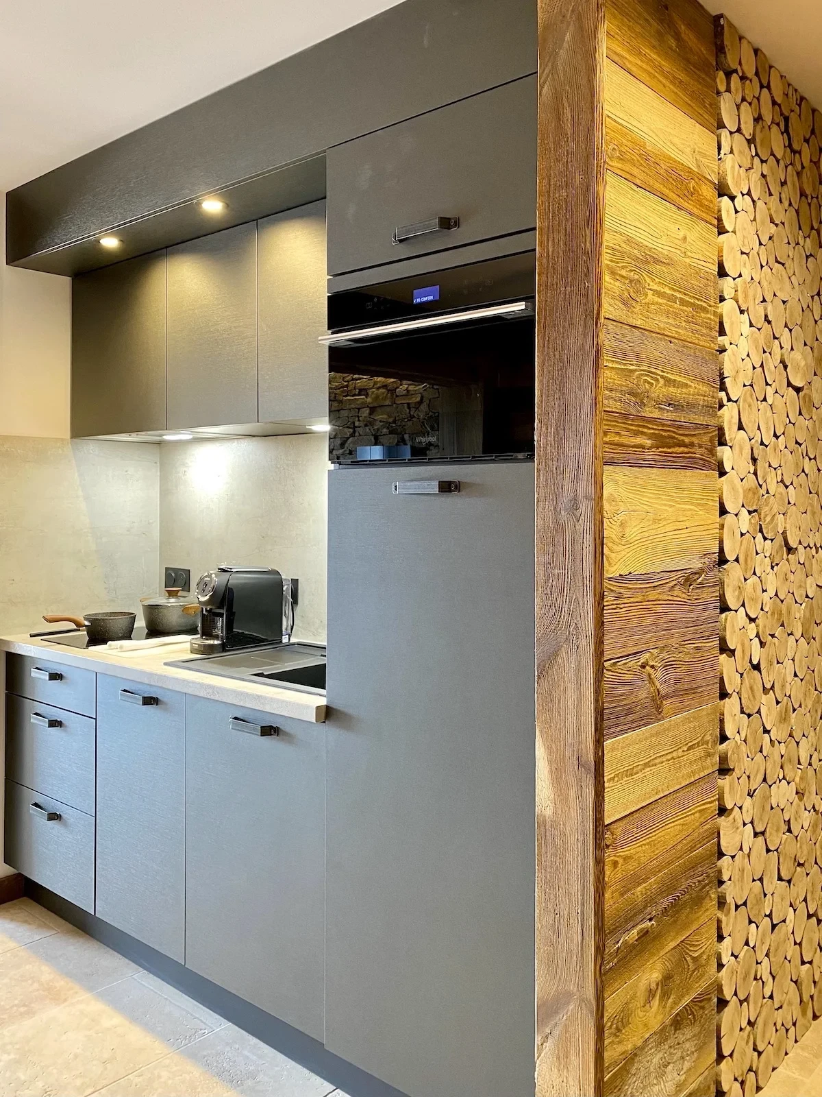 Cuisine moderne grise avec mur en bois décoratif