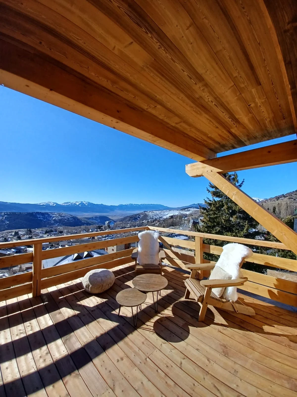 Terrasse en bois avec vue sur montagnes enneigées