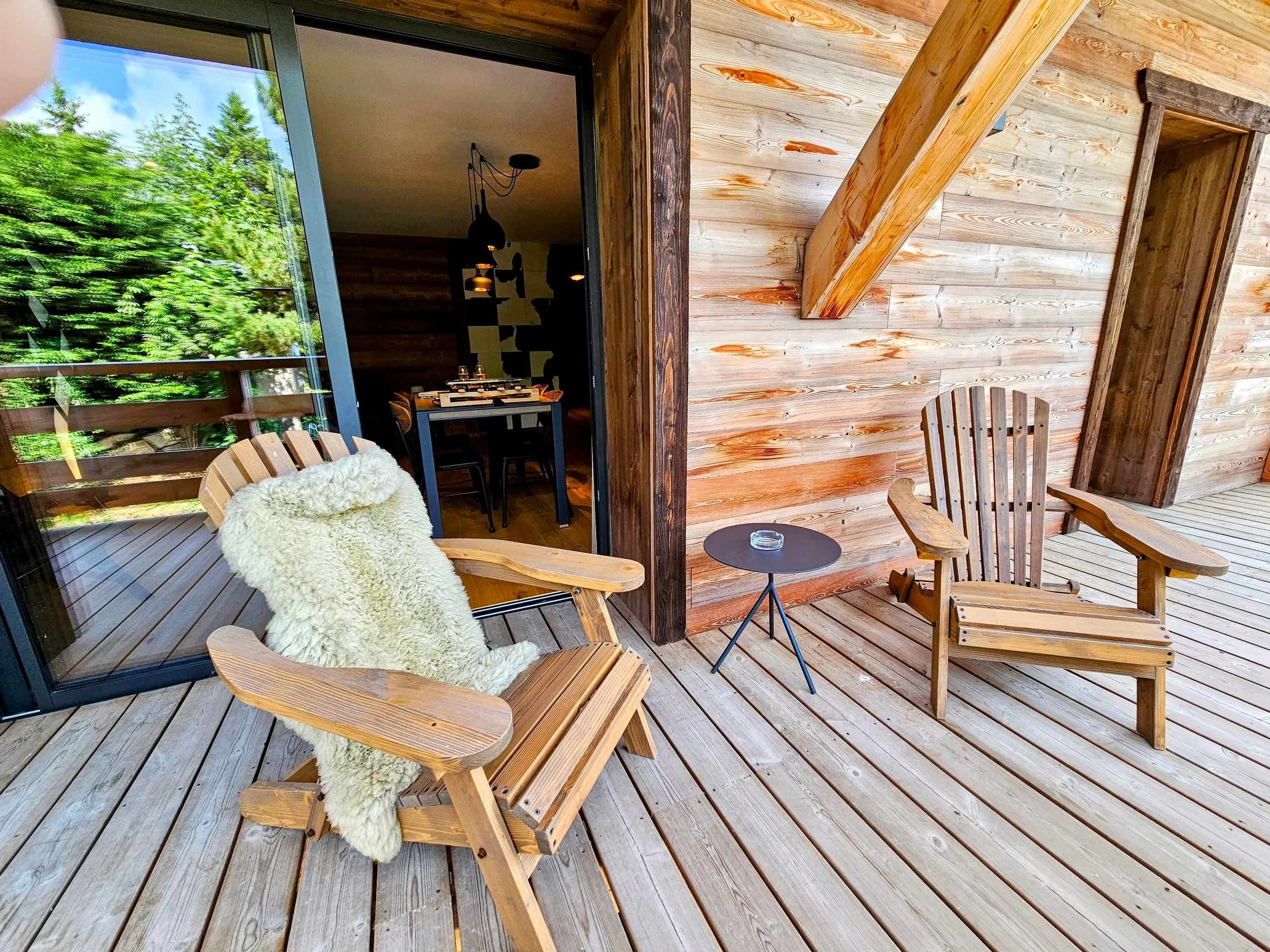 Terrasse en bois avec fauteuils face à la forêt