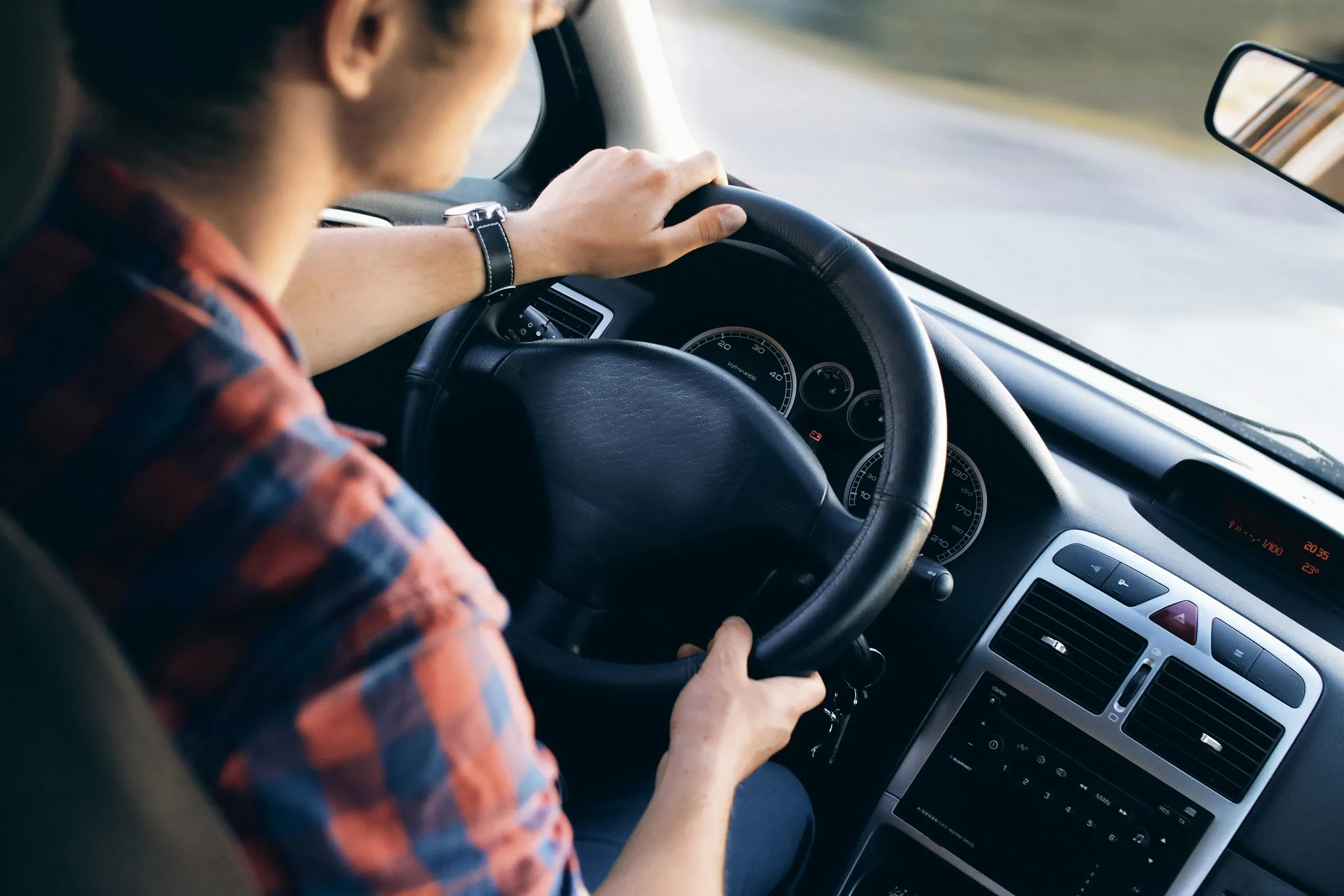 Conducteur tenant le volant d'une voiture en marche