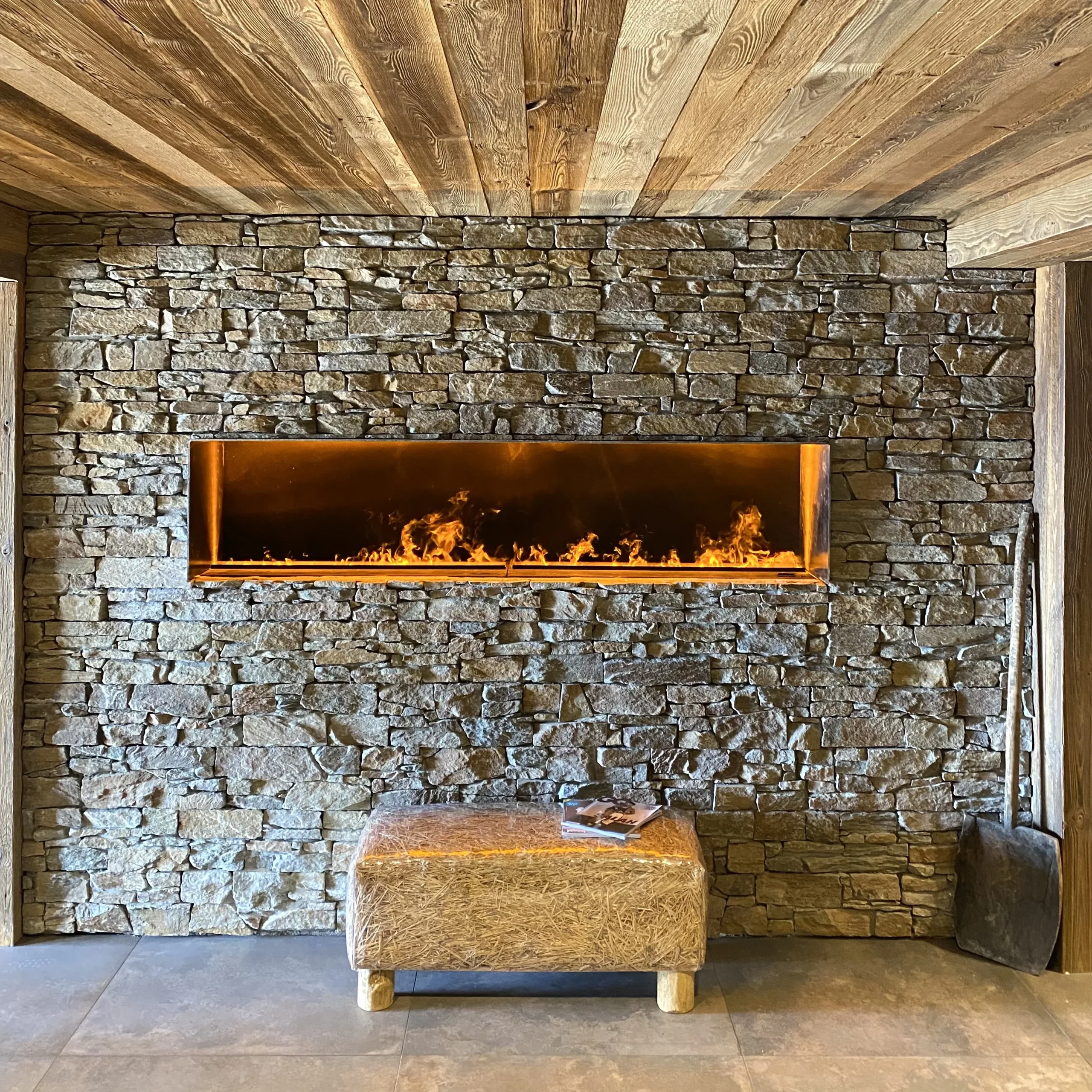 Cheminée moderne encastrée dans mur en pierre