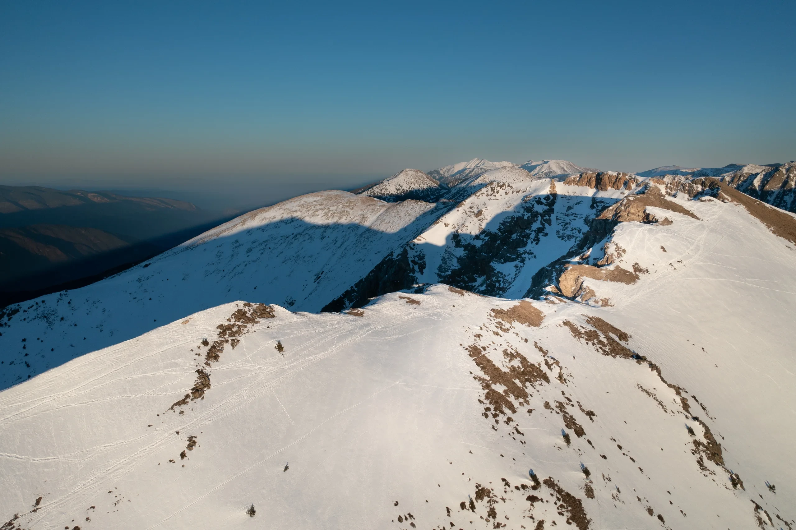 Crête de montagne enneigée au coucher du soleil