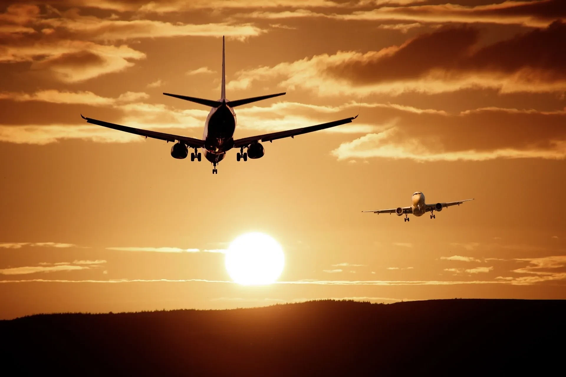 Deux avions atterrissant au coucher du soleil